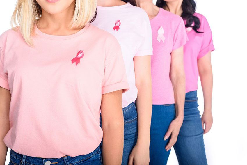 Молодые женщины с символом борьбы против рака молочной железы “Розовая лента”